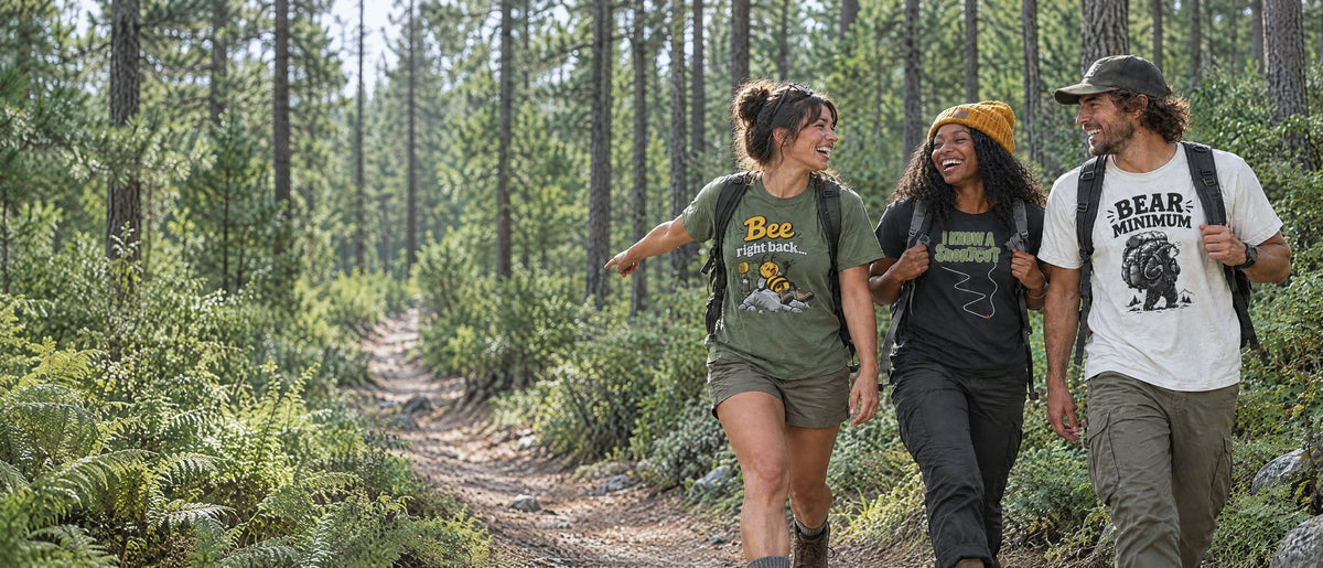 Three friends laughing on a forest trail in Blisterhood tees